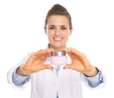 glimlachend schoonheidsspecialist vrouw weergegeven: fles crème