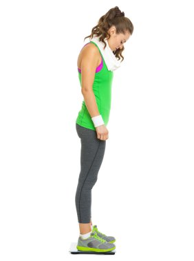 tam uzunlukta ölçekler üzerinde duran fitness genç kadın portresi