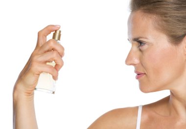 Genç bir kadın parfüm sıkıyor.