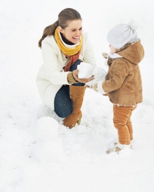 mutlu anne ve bebek kış Park'ta kardan adam yapma