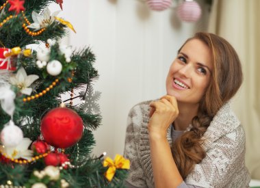 düşünceli Noel ağacının yanında genç bir kadın portresi