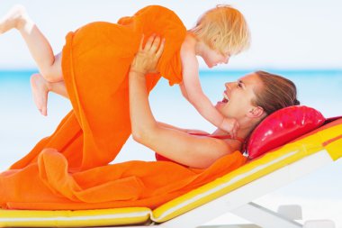 mutlu anne ve bebek şezlong üzerinde oynama