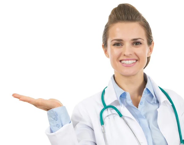 Mujer doctora sonriente presentando algo en la palma vacía — Foto de Stock