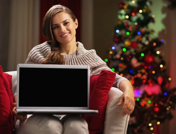 Улыбающаяся молодая женщина показывает ноутбук чистый экран — стоковое фото