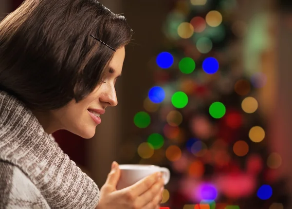 Joyeux jeune femme avec tasse de chocolat chaud devant Noël — Photo
