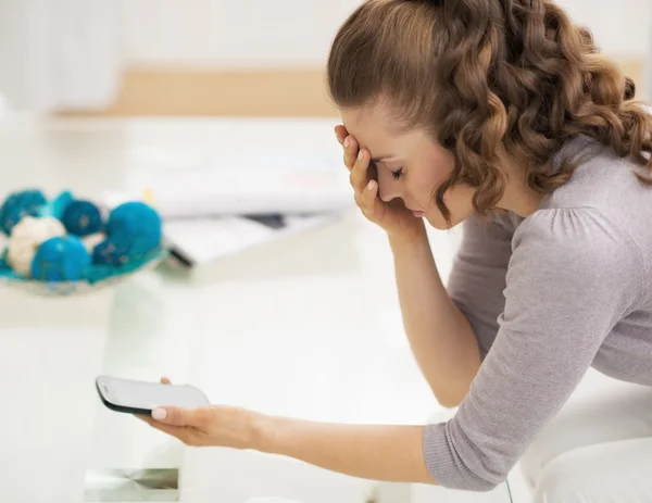 Mujer joven estresada sosteniendo el teléfono celular —  Fotos de Stock