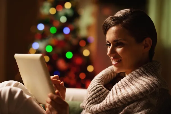 Jovem feliz usando tablet pc na frente da árvore de Natal — Fotografia de Stock