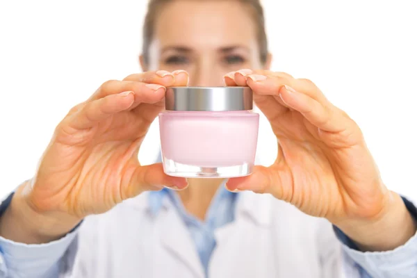 Closeup on cream bottle in hand of cosmetologist — Stock Photo, Image