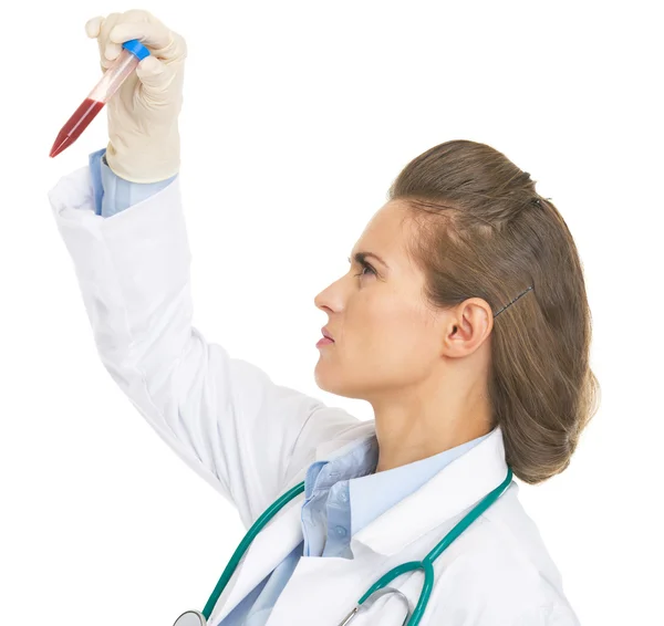 Serious doctor woman checking test tube — Stock Photo, Image