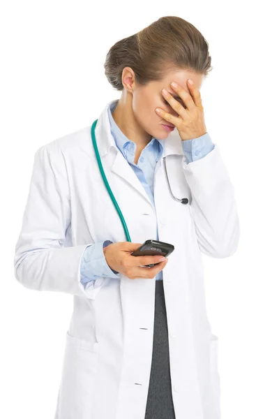 Frustrated doctor woman with cell phone — Stock Photo, Image