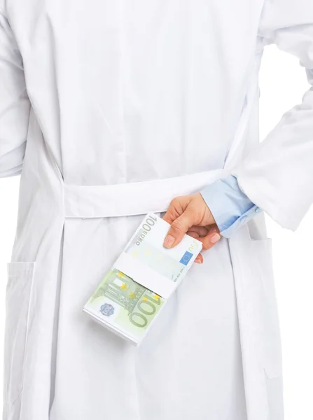 Nahaufnahme einer Ärztin, die einen Stapel Dollars hinter dem Rücken versteckt — Stockfoto