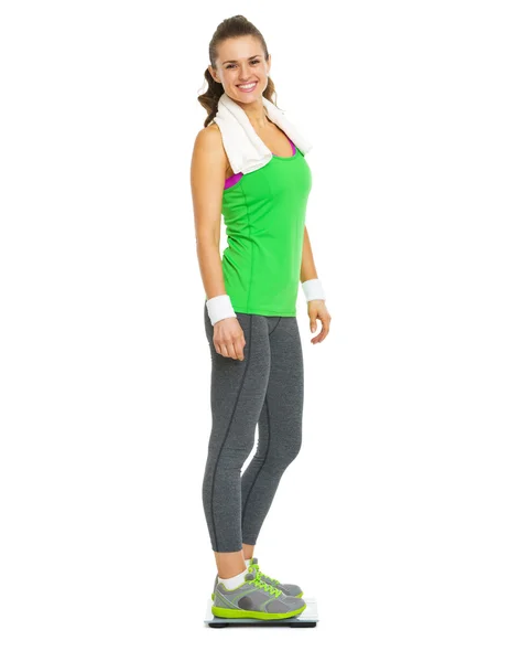 Smiling fitness young woman standing on scales — Stock Photo, Image