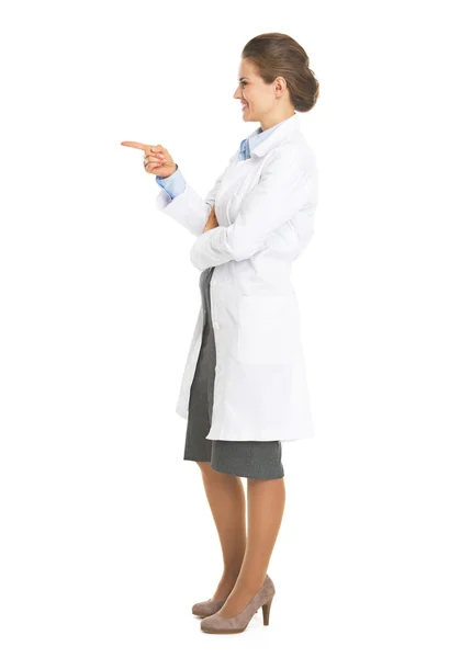 Full length portrait of smiling doctor woman pointing on copy sp — Stock Photo, Image