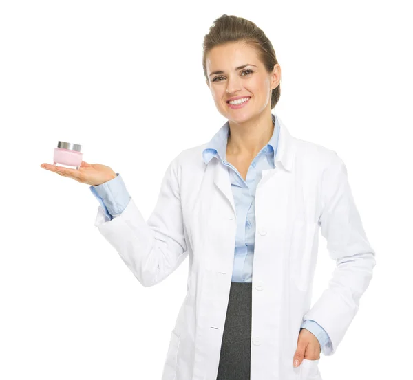 Smiling cosmetologist woman showing cream bottle — Stock Photo, Image