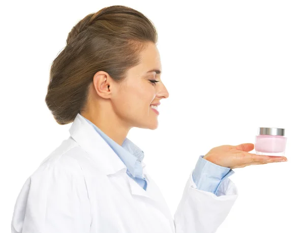 Cosmétologue souriante médecin femme présentant bouteille de crème — Photo