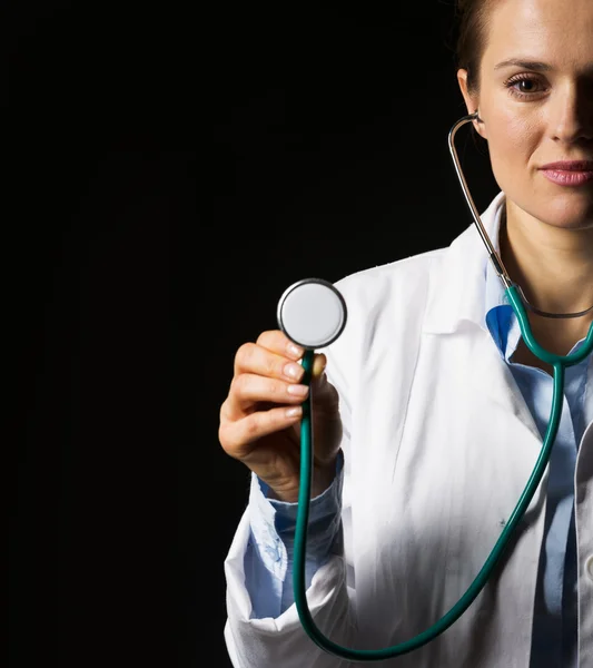 Mulher médica usando estetoscópio isolado em preto — Fotografia de Stock