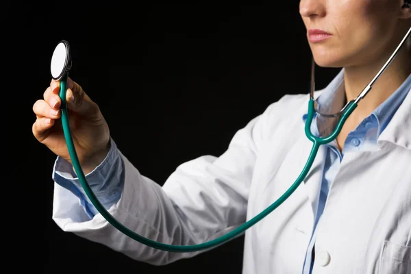 Gros plan sur médecin femme en utilisant stéthoscope isolé sur noir — Photo