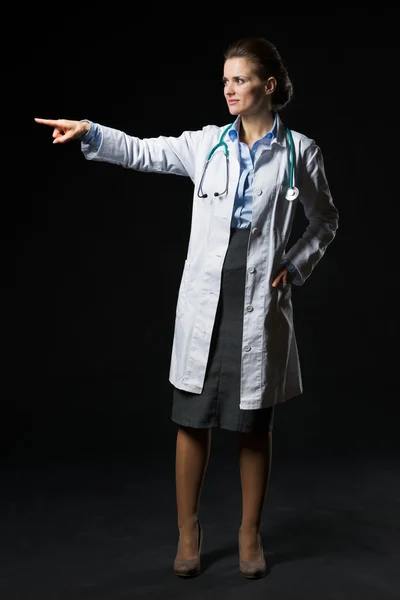 Portrait complet de la femme médecin pointant sur l'espace de copie isol — Photo