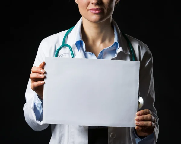 Fechar na mulher médica mostrando folha de papel em branco isolado — Fotografia de Stock