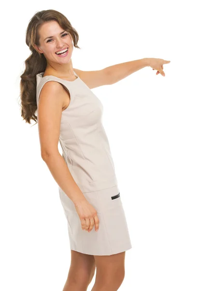 Lächelnde junge Frau zeigt auf Kopierraum — Stockfoto