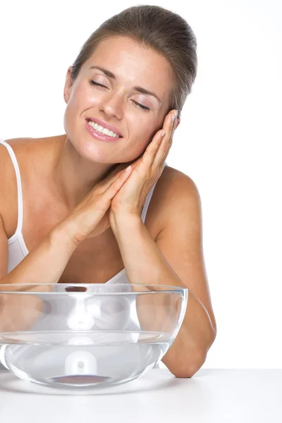 Mujer joven y cuenco de vidrio con agua disfrutando de frescura —  Fotos de Stock