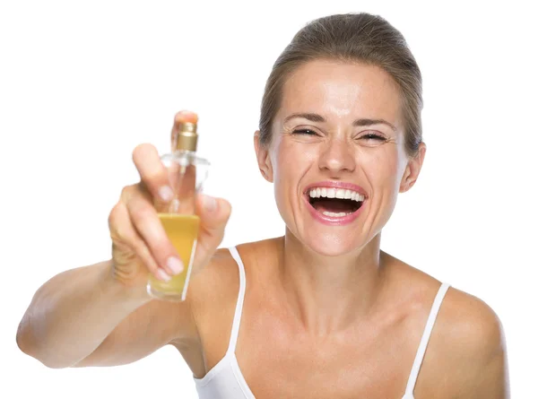 Glückliche junge Frau, die Parfüm in die Kamera aufträgt — Stockfoto