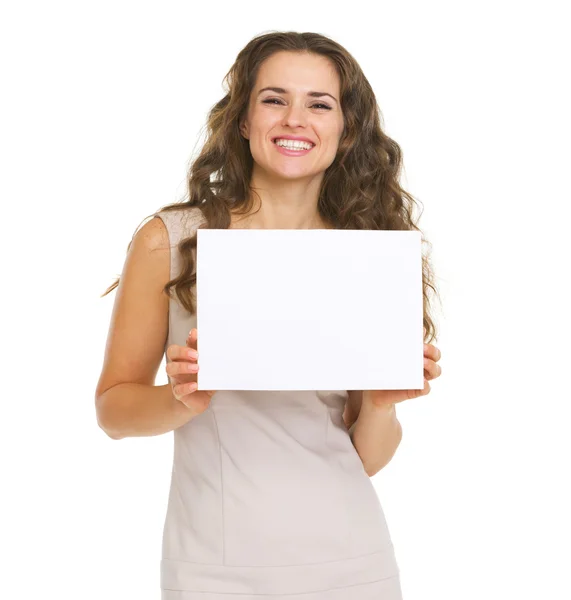 Portrait de jeune femme heureuse montrant du papier vierge — Photo