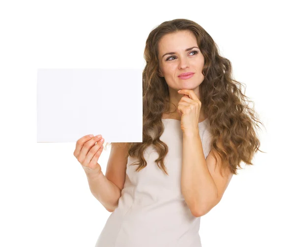 Mujer joven reflexiva sosteniendo papel en blanco — Foto de Stock