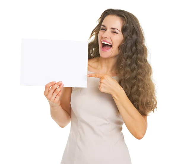 Mujer joven sonriente señalando en una hoja de papel en blanco — Foto de Stock