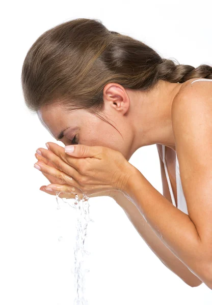 Feliz joven mujer haciendo salpicaduras de agua mientras se lava la cara — Foto de Stock