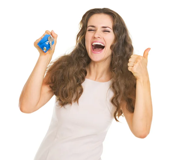 Happy young woman showing keys and thumbs up — Stock Photo, Image