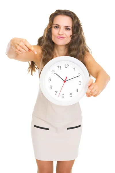 Concerned young woman pointing on clock — Stock Photo, Image