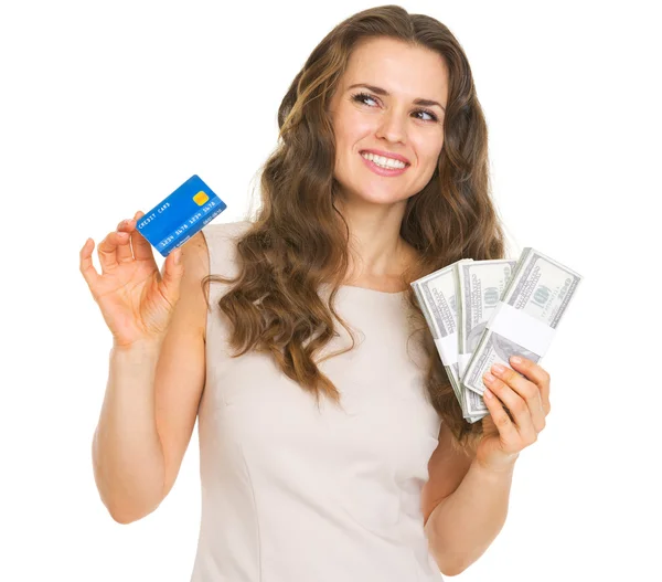 Jeune femme réfléchie avec carte de crédit et dollars regardant sur c — Photo