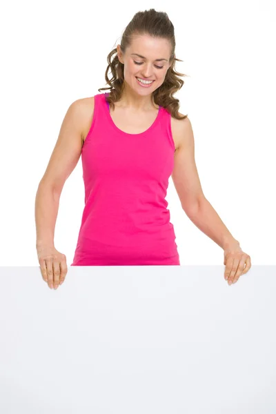 Smiling fitness young woman showing blank billboard — Stock Photo, Image