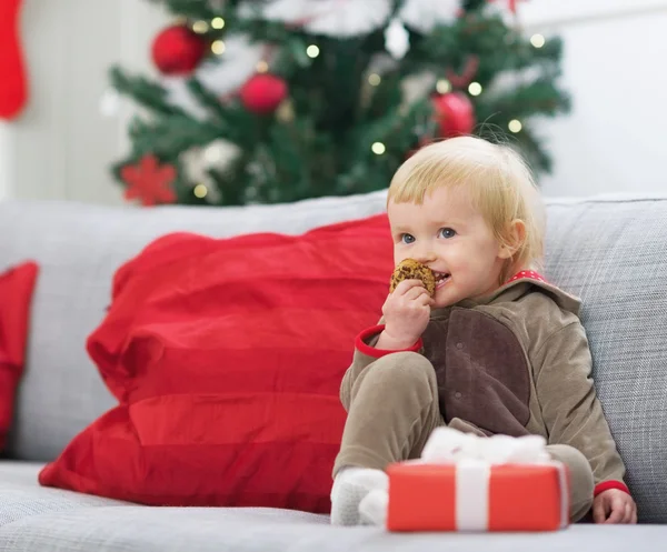 Glückliches Baby im Weihnachtskostüm isst Plätzchen — Stockfoto