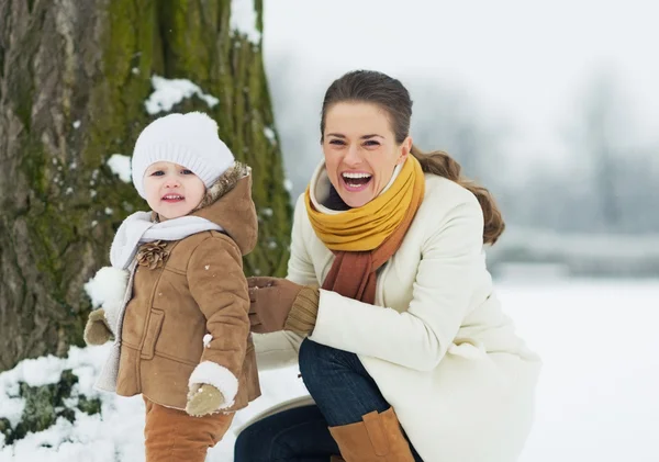 Bonne mère et bébé jouant à l'extérieur en hiver — Photo