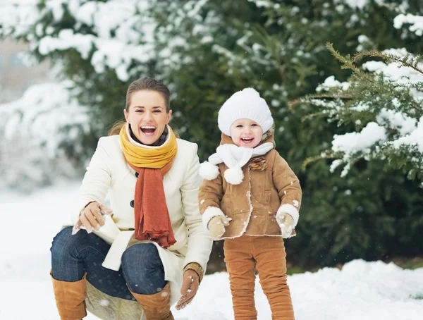 Portrait of happy mother and baby in winter park — Stock Photo, Image