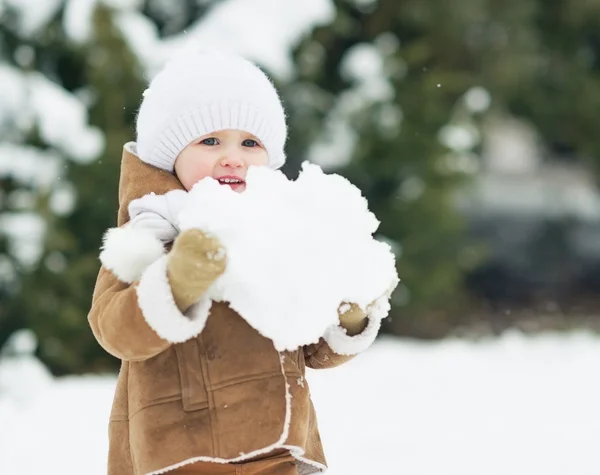 Bébé tenant grosse boule de neige — Photo