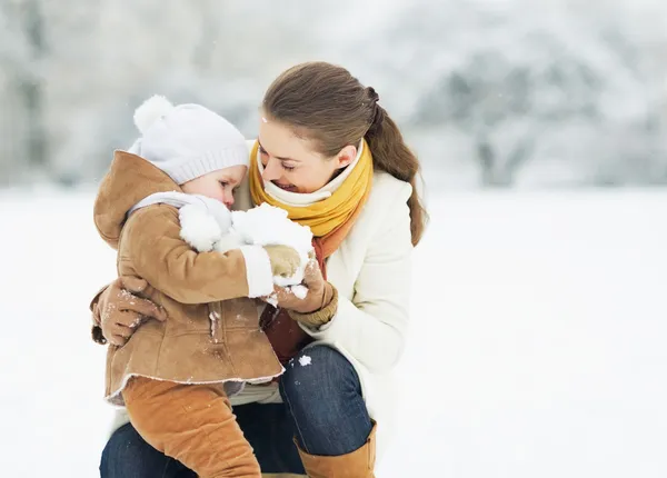 Mutter und Baby spielen im Winterpark — Stockfoto