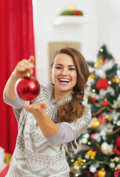 Jovem feliz mostrando bola de Natal — Fotografia de Stock