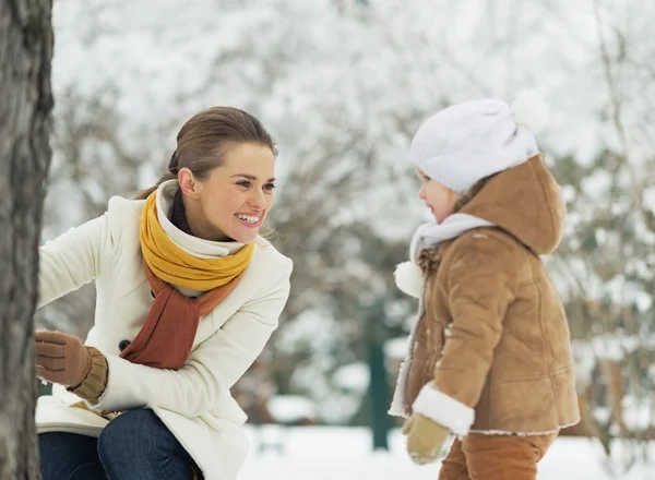 Happy mother playing with baby in winter park — Stock Photo, Image
