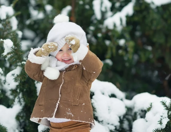 Porträtt av glad bebis tittar ut från hat i Vinterparken — Stockfoto