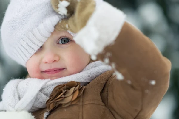 Portrait of happy baby looking out from hat in winter park — Stock Photo, Image
