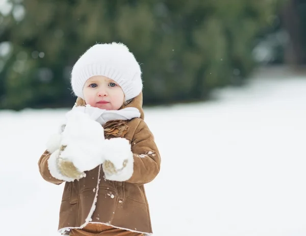 Bambino che gioca con la neve nel parco invernale — Foto Stock