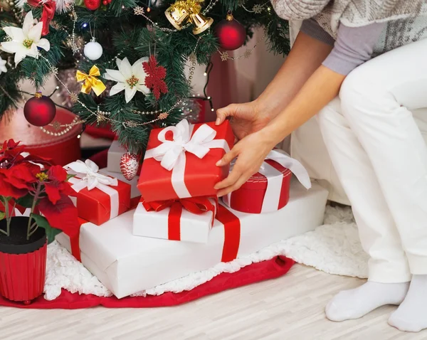 Closeup on young woman taking present box from under christmas t — Stock Photo, Image