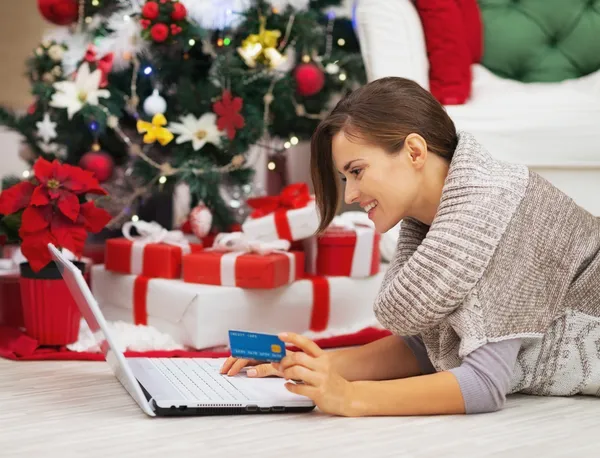 Ευτυχισμένη κοπέλα με πιστωτική κάρτα χρησιμοποιώντας φορητό υπολογιστή κοντά Χριστούγεννα t — Φωτογραφία Αρχείου