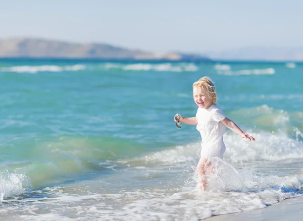 Happy baby running into sea — Stock Photo, Image