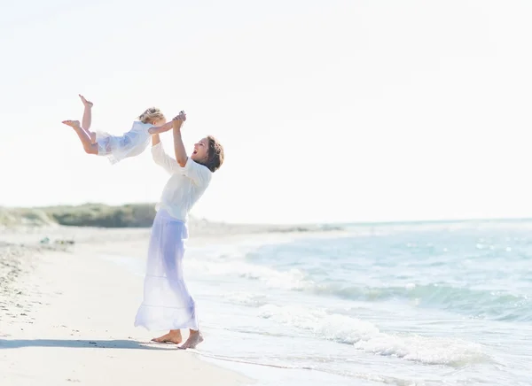 Happy matka s dítětem hrát na pláži — Stock fotografie