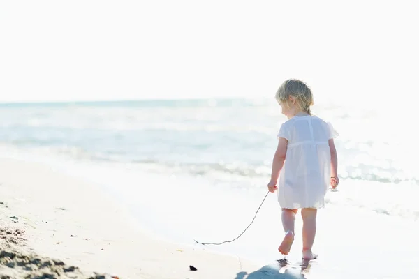 Bambino solitario che cammina al mare. vista posteriore — Foto Stock