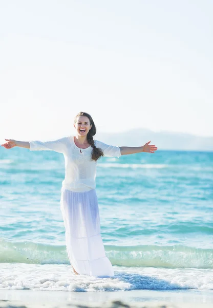 Glad ung kvinna jubel vid havets strand — Stockfoto